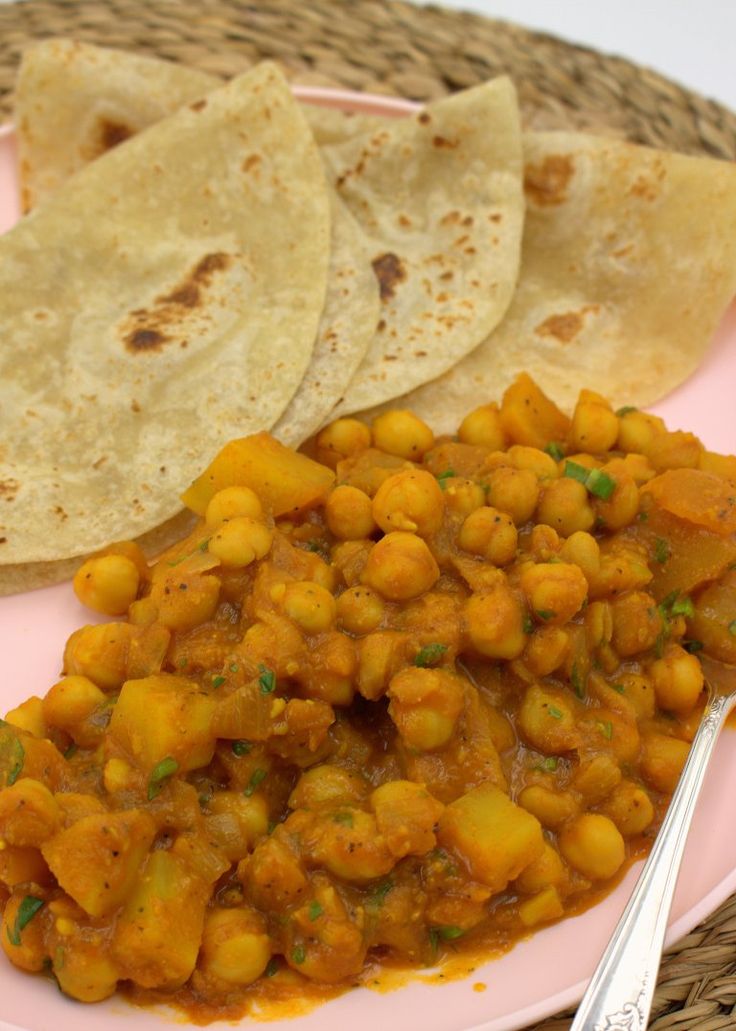 Indian chole aloo curry next to folded rotis on a serving plate.
